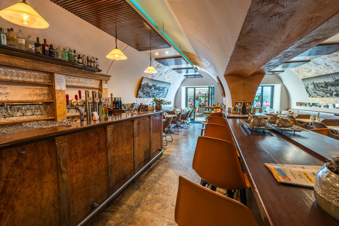 Die Bar im Cavallo mit Flaschenregal, Lampen und Barhockern
