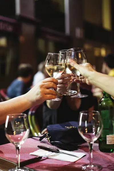 Freunde stoßen mit Weißwein an