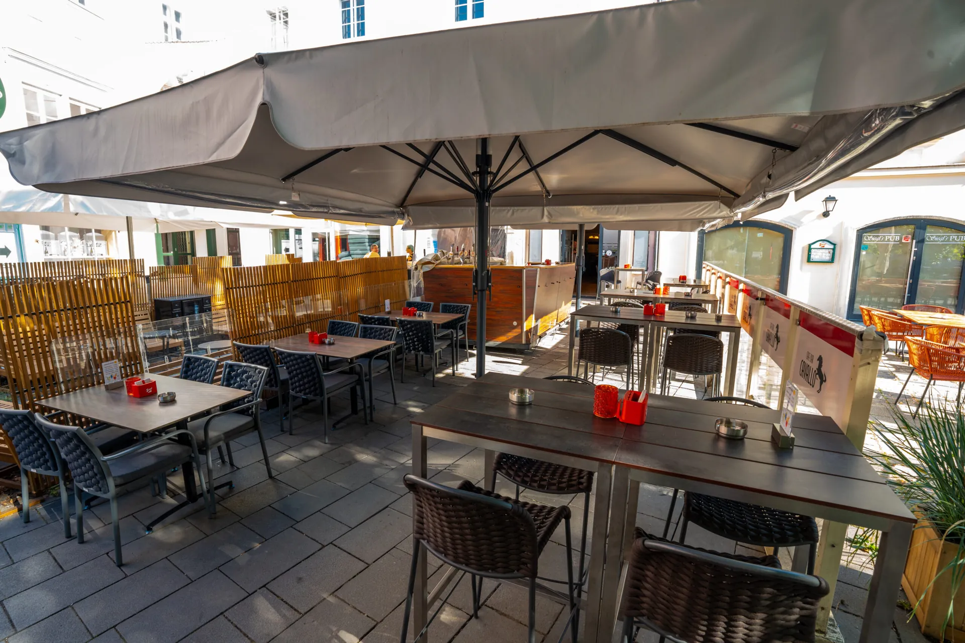 Gastgarten des Cavallo mit Sonnenschirmen und Tischen am Hauptplatz