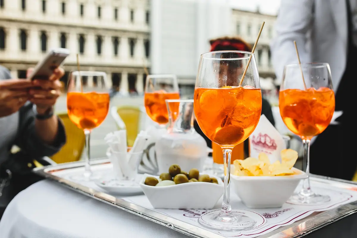 Aperol Spritz, Oliven und Chips auf einem Tablett